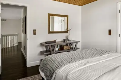 a bedroom with a bed and a table with a mirror at Hot Tub - Scenic Views - Spacious Deck - Game Room in Evergreen
