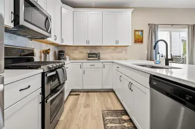 a kitchen with white cabinets and a sink at Sunny & Quaint Hidden Gem w Office - Dog Friendly in Westminster