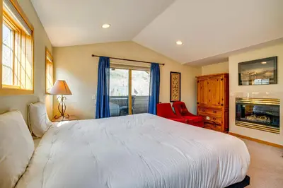 a bedroom with a large white bed and a fireplace at 8 Mi to Skiing Mtn-View Getaway in Frisco! in Frisco