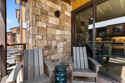 two chairs on a porch with a stone wall at Blue R Flats Bld 3 203 in Silverthorne