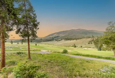 a view of a golf course with mountains in the background at Blue R Flats Bld 3 203 in Silverthorne