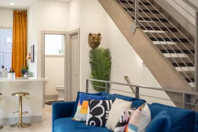 a living room with a blue couch and a cat on the wall at Roof Deck - MTN View - Hot Tub - Cold Plunge in Silverthorne