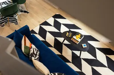 a living room with a blue couch and a black and white rug at Roof Deck - MTN View - Hot Tub - Cold Plunge in Silverthorne