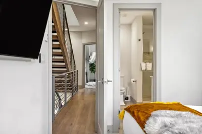 a bedroom with a bed and a hallway with a staircase at Roof Deck - MTN View - Hot Tub - Cold Plunge in Silverthorne