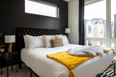 a bedroom with a large white bed with a large window at Roof Deck - MTN View - Hot Tub - Cold Plunge in Silverthorne