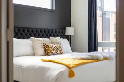 a bedroom with a white bed with a black headboard at Roof Deck - MTN View - Hot Tub - Cold Plunge in Silverthorne