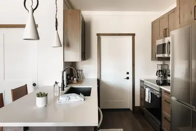 a kitchen with a sink and a refrigerator at New Luxe Condo - Hot Tub - Minutes to WP! - Fraser in Fraser