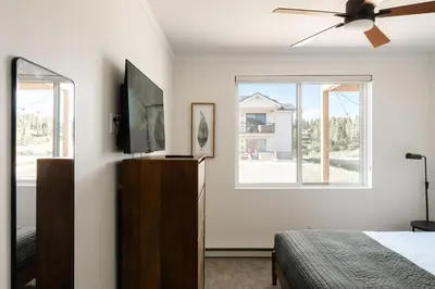 a bedroom with a bed and a ceiling fan at New Luxe Condo - Hot Tub - Minutes to WP! - Fraser in Fraser