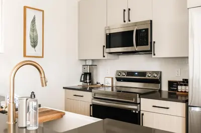 a kitchen with stainless steel appliances and a microwave at New Modern Charm - Hot Tub - Deck Views! - Fraser in Fraser