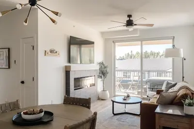 a living room with a table and a fireplace at New Modern Charm - Hot Tub - Deck Views! - Fraser in Fraser