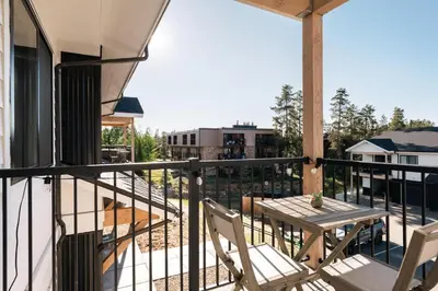 a patio with a table and chairs on a balcony at New Modern Charm - Hot Tub - Deck Views! - Fraser in Fraser