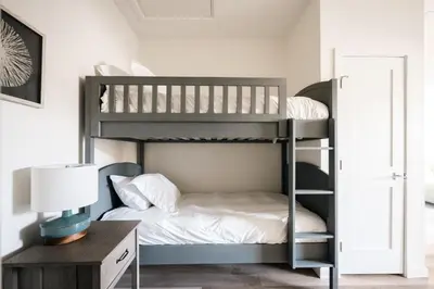 a bunk bed in a room with a desk and a lamp at Chic Condo - Near Town and Trails - Hot Tub - Deck in Fraser