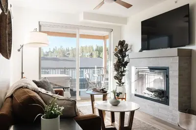 a living room with a couch and a fireplace at Chic Condo - Near Town and Trails - Hot Tub - Deck in Fraser