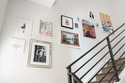 a staircase with pictures on a white wall at Vogue Posh Pad - Center of LoHi - Large Roof Deck in Denver