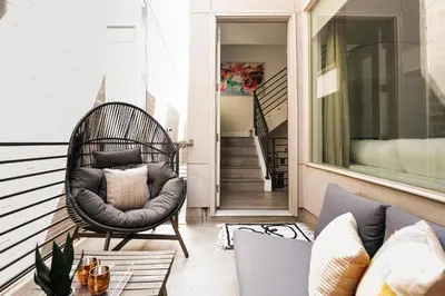 a porch with a wicker chair and a couch at Vogue Posh Pad - Center of LoHi - Large Roof Deck in Denver