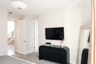 a living room with a tv on a white wall at Vogue Posh Pad - Center of LoHi - Large Roof Deck in Denver