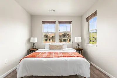 a bedroom with a large bed with two windows at Aspen Meadows Condo in the beautiful area of Granby Ranch! in Granby