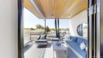 a living room with a blue couch on a balcony at Luxurious, Modern Townhome 5 minute Walk from Cherry Creek North in Denver