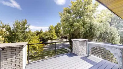 a large deck with a black fence and trees at Luxurious, Modern Townhome 5 minute Walk from Cherry Creek North in Denver