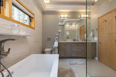 a bathroom with a tub and a sink and a mirror at 13 Liftside townhouse in Keystone