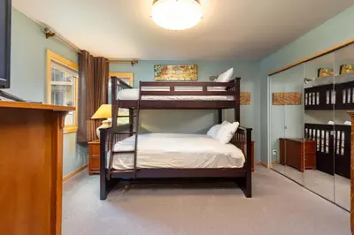 a bedroom with two bunk beds and a television at 13 Liftside townhouse in Keystone