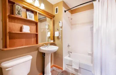 a bathroom with a toilet and a sink and a tub at Select Unit 1710 - 2BR - Zephyr Mountain Lodge condo in Winter Park