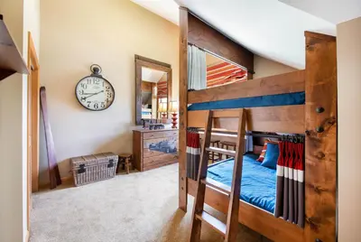 a bedroom with a bunk bed and a clock on the wall at Select Unit 1710 - 2BR - Zephyr Mountain Lodge condo in Winter Park