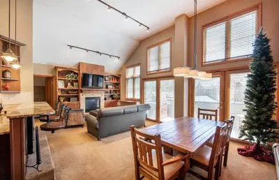 a kitchen and living room with a table and a couch at Select Unit 1710 - 2BR - Zephyr Mountain Lodge condo in Winter Park