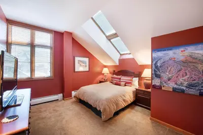 a bedroom with a bed with red walls and skylights at Select Unit 1710 - 2BR - Zephyr Mountain Lodge condo in Winter Park
