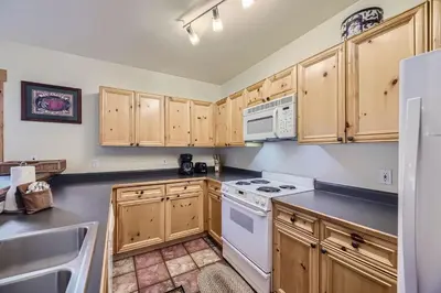 a kitchen with wooden cabinets and a white stove top oven at 2652 Tenderfoot Lodge condo in Keystone