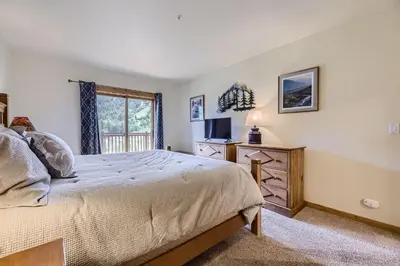 a bedroom with a bed and a television and a window at 2652 Tenderfoot Lodge condo in Keystone