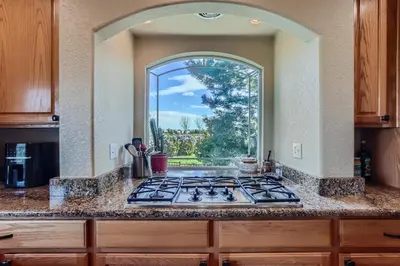 a kitchen with a stove and an arch window at Denver Retreat Home with Stunning Lake, Mountain Views and Luxury Amenities in Denver