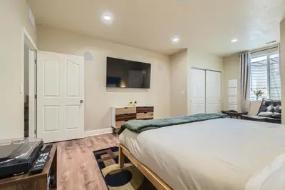 a bedroom with a bed and a flat screen tv at Denver Retreat Home with Stunning Lake, Mountain Views and Luxury Amenities in Denver