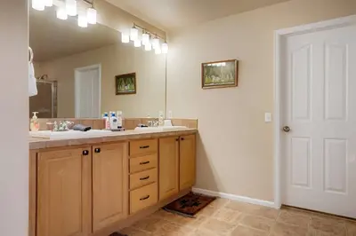a bathroom with two sinks and a large mirror at Denver Retreat Home with Stunning Lake, Mountain Views and Luxury Amenities in Denver