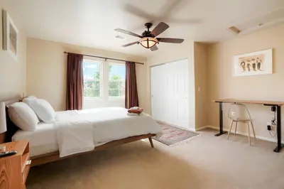 a bedroom with a bed and a ceiling fan at Denver Retreat Home with Stunning Lake, Mountain Views and Luxury Amenities in Denver