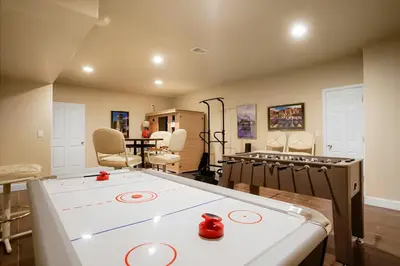 a room with a ping pong table and chairs at Denver Retreat Home with Stunning Lake, Mountain Views and Luxury Amenities in Denver