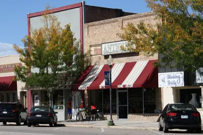 a city street with cars parked in front of buildings at Downtown Windsor Home with Hot Tub and Pool Table in Windsor