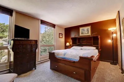 a bedroom with a bed and a tv and windows at Orofino Dillon 104 condo in Dillon