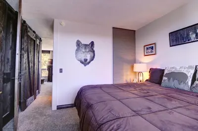 a bedroom with a bed with a wolf head on the wall at Orofino Dillon 104 condo in Dillon