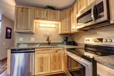 a kitchen with wooden cabinets and stainless steel appliances at Orofino Dillon 104 condo in Dillon