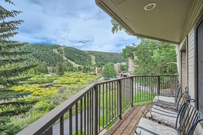 a balcony with two chairs and a view of a valley at 122 Cinnamon Ridge condo in Keystone