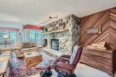 a large living room with a stone fireplace at 122 Cinnamon Ridge condo in Keystone