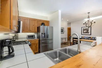 a kitchen with wooden cabinets and a stainless steel refrigerator at 8721 Ski Tip Townhomes townhouse in Keystone