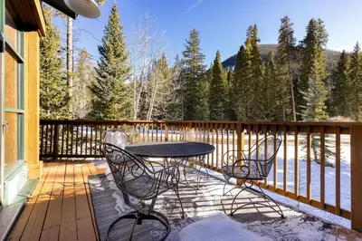 a patio with a table and chairs on a deck at 8721 Ski Tip Townhomes townhouse in Keystone