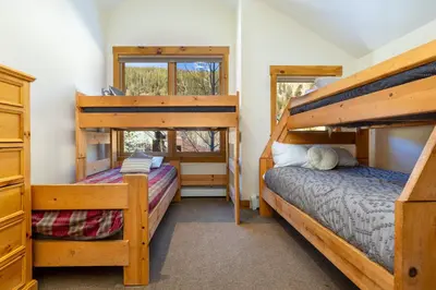 two bunk beds in a room with two windows at 8721 Ski Tip Townhomes townhouse in Keystone