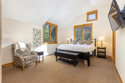 a bedroom with a bed and a piano and a chair at 8721 Ski Tip Townhomes townhouse in Keystone