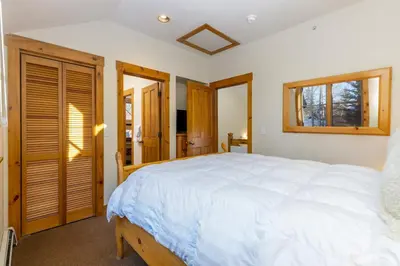 a bedroom with a large bed and two windows at 8721 Ski Tip Townhomes townhouse in Keystone