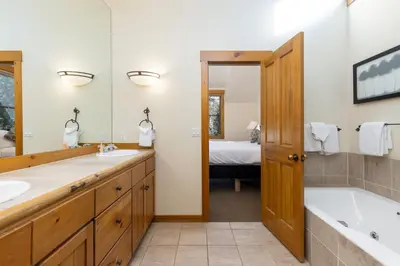 a bathroom with two sinks and a bath tub and a tubermott at 8721 Ski Tip Townhomes townhouse in Keystone