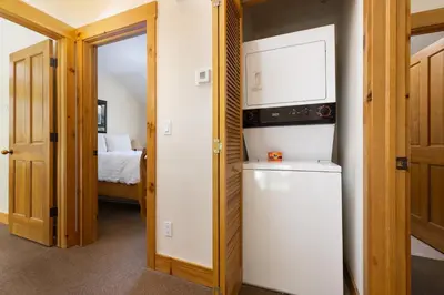 a small kitchen with a refrigerator and a bedroom at 8721 Ski Tip Townhomes townhouse in Keystone