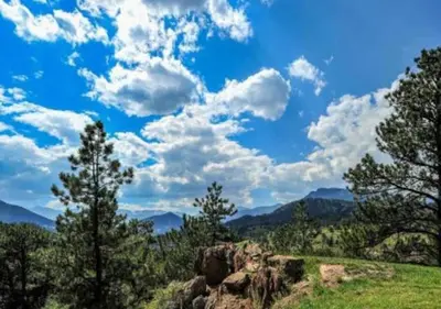 a blue sky with clouds and trees on a hill at Diamond - The Historic Crags Lodge - ST in Estes Park